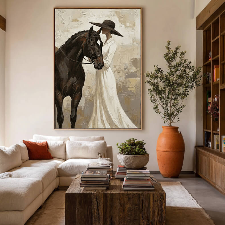 neutral cowgirl and black horse wall art in cream and white displayed in a styled living room